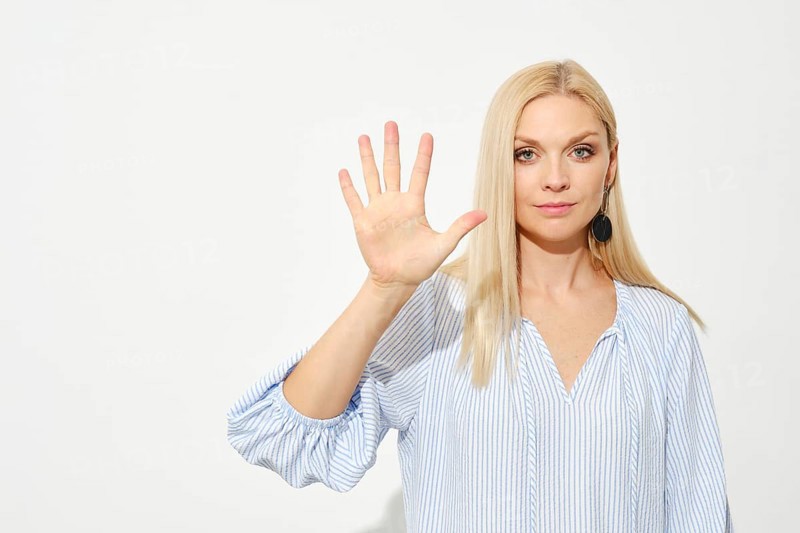 Attractive blonde woman shows five fingers. Counting with fingers