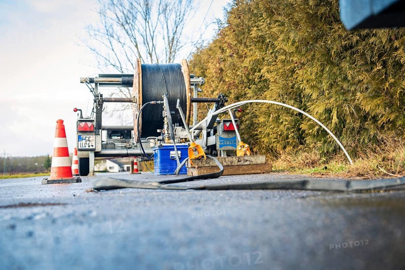 Road work equipment with wet surface and cable reel in the foreground, fibre optic construction, Nagold, Black Forest, Germany, Europe