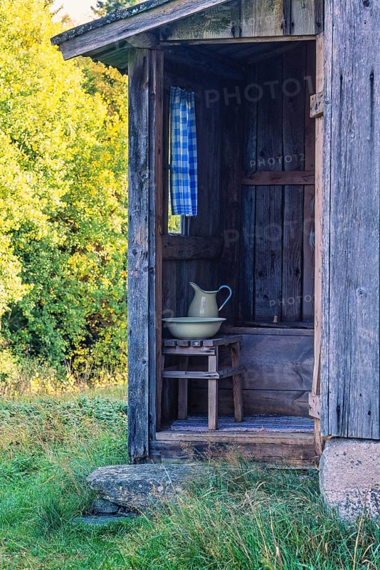 Idyllic old outhouse with a jug and sink in the country at summer, Sweden, Europe