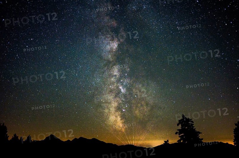 Milky Way over the Chiemgau Alps with the Sonntagshorn, the rays on the horizon seem to come from a light show or laser show near Kitzbühel, Inzell, Bavaria, Germany, Europe
