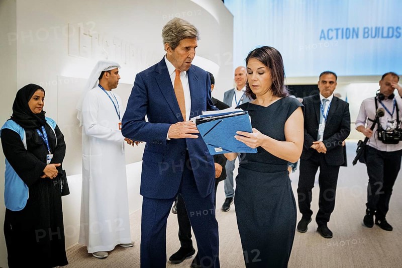 Annalena Baerbock (Buendnis 90 Die Gruenen), Bundesaussenministerin, trifft John Kerry, Sondergesandter des US-Praesidenten fuer das Klima, auf dem Weg ins Plenum der COP28 in Dubai, 13.12.2023