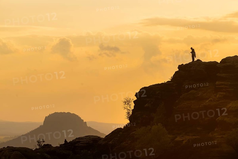 Climbers on the Schrammsteine in the Elbe Sandstone Mountains with the Lilienstein in the background