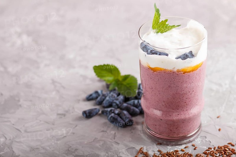 Smoothie with honeysuckle, linen and chia in a glass on gray concrete background. side view, close up, selective focus