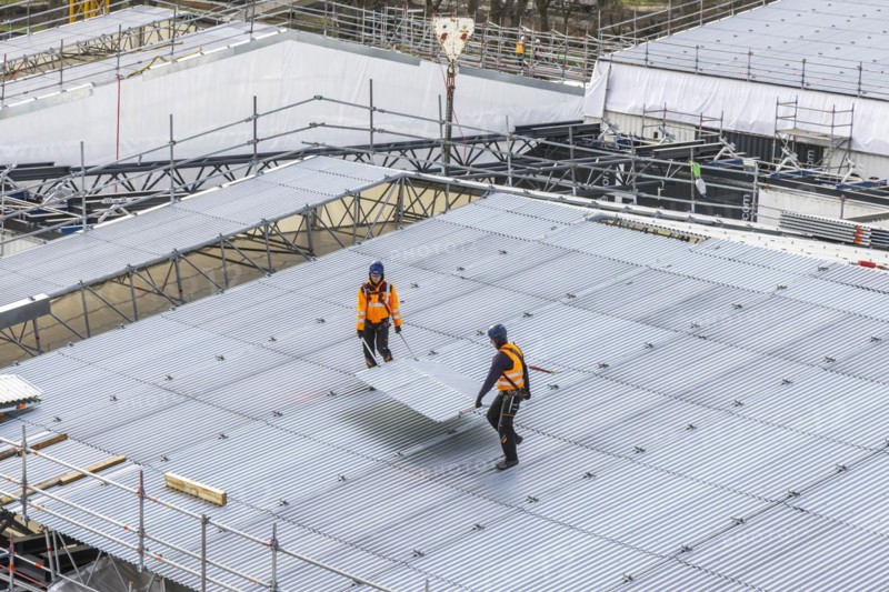 Construction workers transport part of a temporary roof. Construction site Stuttgart21. Stuttgart, Baden-Württemberg, Germany, Europe