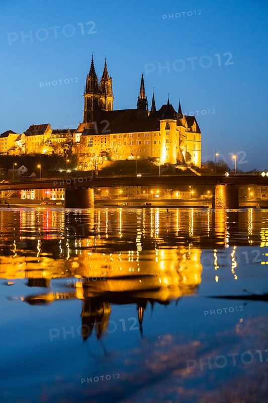 The Elbe in Meissen is slightly high water after the snow has melted, the Burgberg is reflected in the river at blue hour