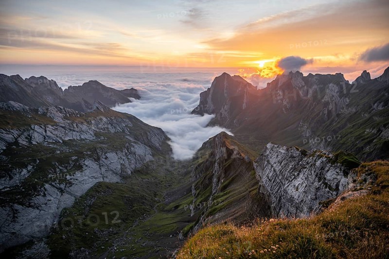 View over SÃ¤ntis mountains into the valley of Meglisalp at sunrise, high fog in the valley, SÃ¤ntis, Appenzell Ausserrhoden, Appenzell Alps, Switzerland, Europe