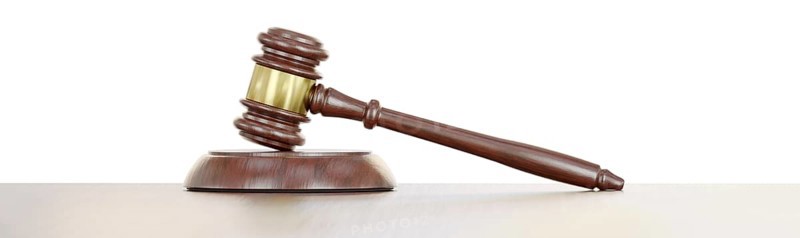 Gavel resting on a wooden table against a white background