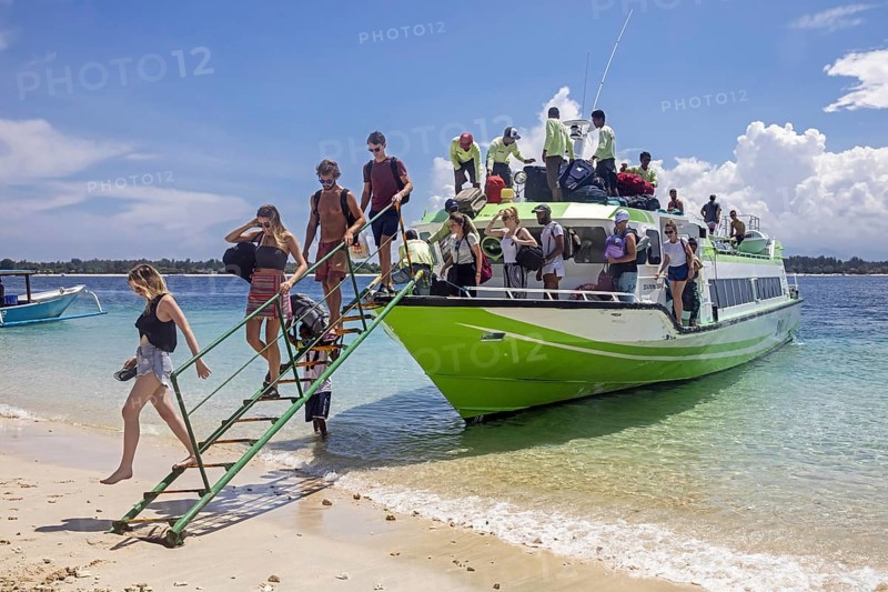 Western tourists debarking from speedboat, fast boat on the island Gili Trawangan, largest of Lombok's Gili Islands, Indonesia, Asia