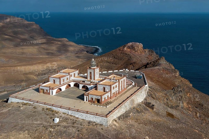 Bird's eye view of aerial view of building complex of lighthouse Faro de la Entallada from 50s year 1953 1954 with large glass dome on 183 metres high cliff, behind it steep coast and Mirador de Entallada, Las Playitas, Tuineje, Las Palmas, Fuerteventura, Canary Islands, Spain, Europe
