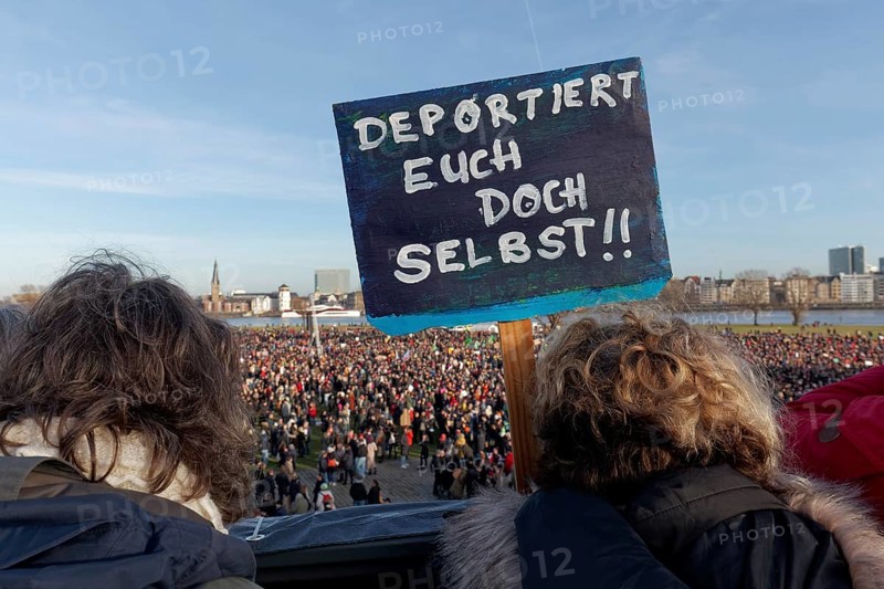 Demonstrators with banner on the topic of remigration, large demonstration against right-wing extremism and AfD on 27 January 2024 in Düsseldorf, North Rhine-Westphalia, Germany, Europe