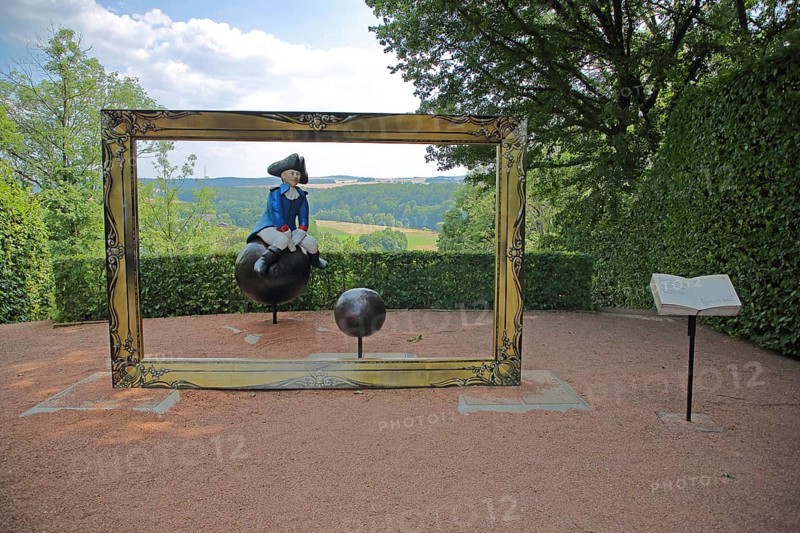 Sculpture Baron von Münchhausen in the castle park, lying baron, uniform, frame, view through, cannonball, sitting, ride, castle, Lichtenwalde, Niederwiesa, Saxony, Germany, Europe