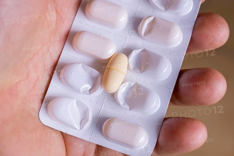 Hand holding a blister pack with a tablet