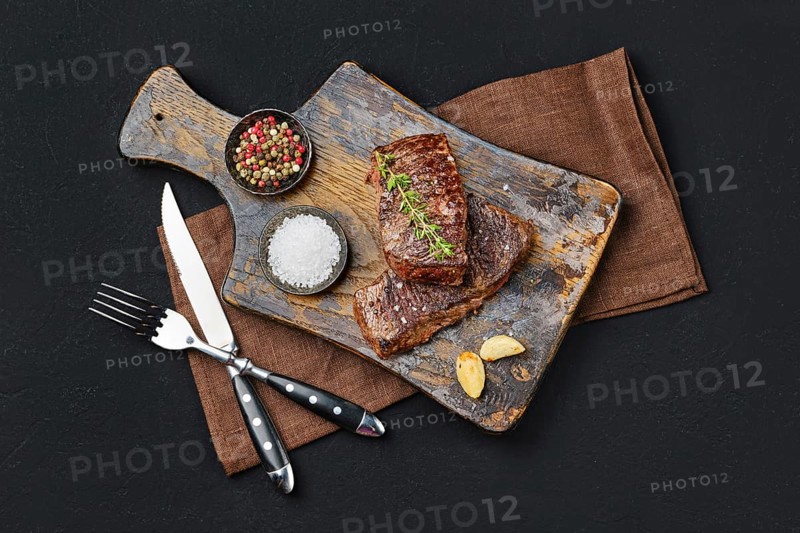 Top view of pan seared beef steak on dark background