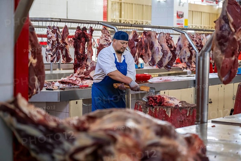 Man chopping meat and bones, butcher's shop with fresh meat, market at Osh bazaar, Bishkek, Kyrgyzstan, Asia