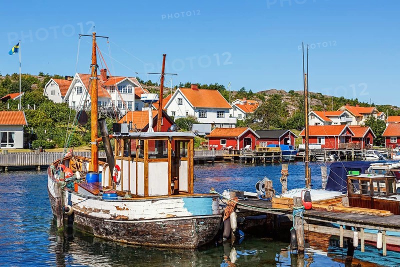 Old fishing boat at a jetty in a fishing village harbour on the Swedish west coast on a sunny summer day, Hamburgsund, BohuslÃ¤n, Sweden, Europe