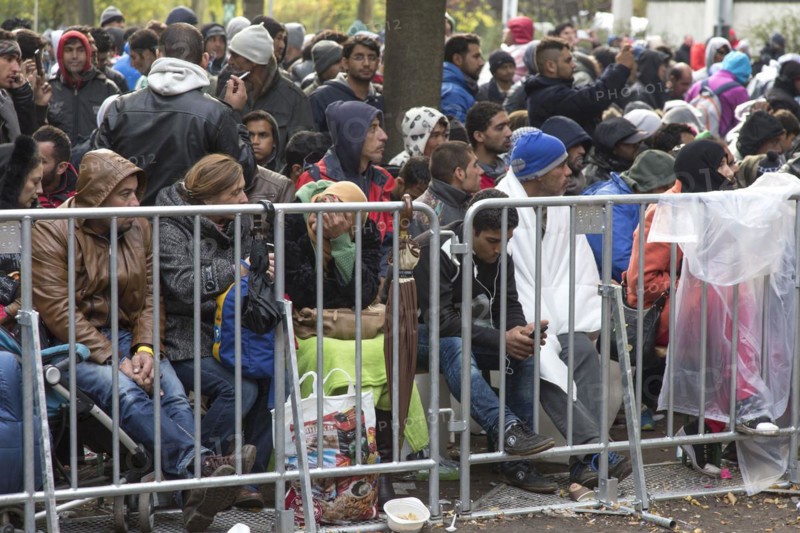 Refugees from Syria wait behind barriers in the Central Reception Centre for Asylum Seekers at the Berlin State Office for Health and Social Affairs for their registration, 09.10.2015