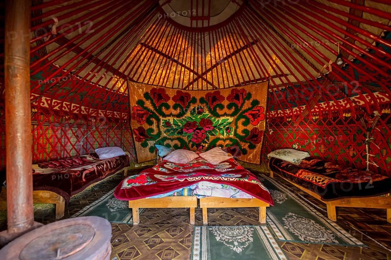 Traditional Kyrgyz yurt for overnight accommodation for tourists, with four beds and carpets, Naryn region, Kyrgyzstan, Asia