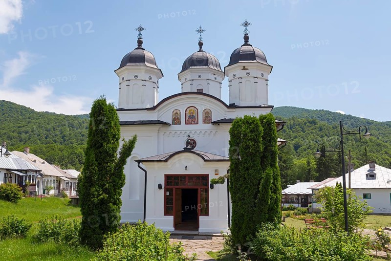A white church with several domes, surrounded by green vegetation and blue sky, Orthodox Nunnery Suzana, Maneciu, MÄƒneciu, Prahova, Muntenia, Romania, Europe