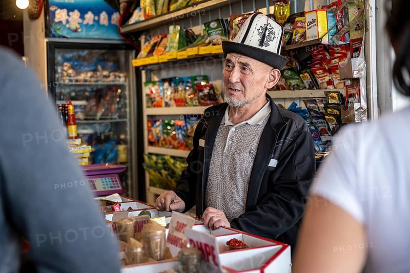 Man with traditional hat selling food, market at Osh bazaar, Bishkek, Kyrgyzstan, Asia