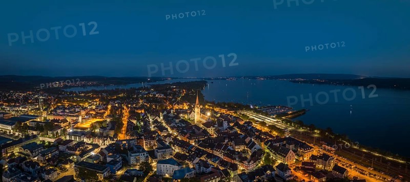 Aerial panorama of the town of Radolfzell at night with the illuminated Radolfzell Minster, Radolfzell am Lake Constance, Landkreis Konstanz, Baden-Württemberg, Germany, Europe