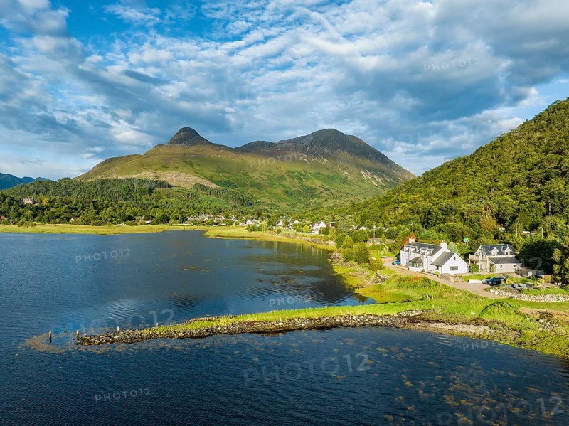 Aerial view of the freshwater loch Loch Leven with the former Pier House in the village of Glen Coe, above which is the 742 metre high Pap of Glencoe, Highlands, Scotland, United Kingdom, Europe