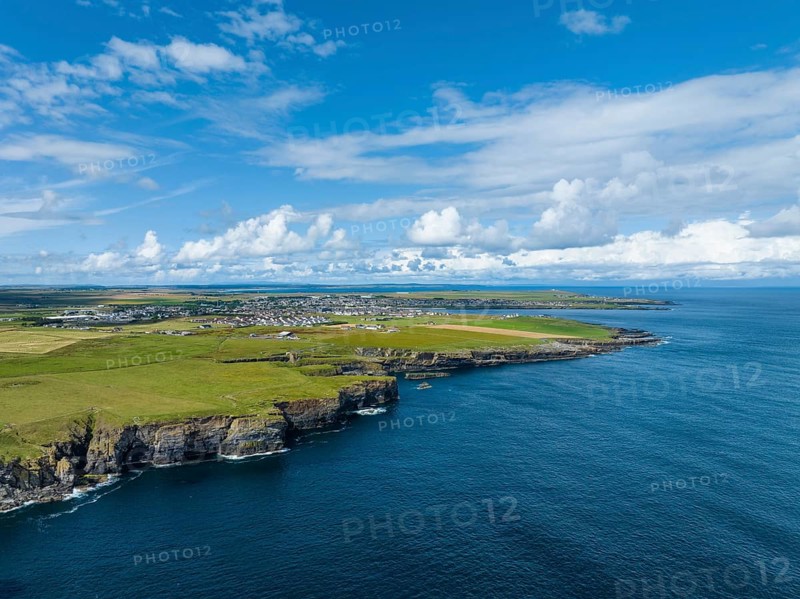 Aerial view of rugged cliffs on the North Sea coast, with the harbour town of Wick on the horizon, County Caithness, Scotland, United Kingdom, Europe