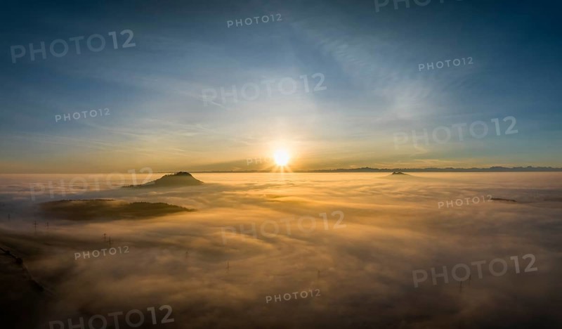 Aerial panorama of the wintry and fog-covered Hegaulandschaft at sunrise, on the left on the horizon the Hohenhewen, on the right the Hohenstoffeln, behind it the Alpine chain, district of Constance, Baden-Württemberg, Germany, Europe