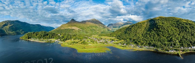 Aerial panorama of the freshwater loch Loch Leven with the village of Glen Coe, above it the 742 metre high Pap of Glencoe, Highlands, Scotland, United Kingdom, Europe