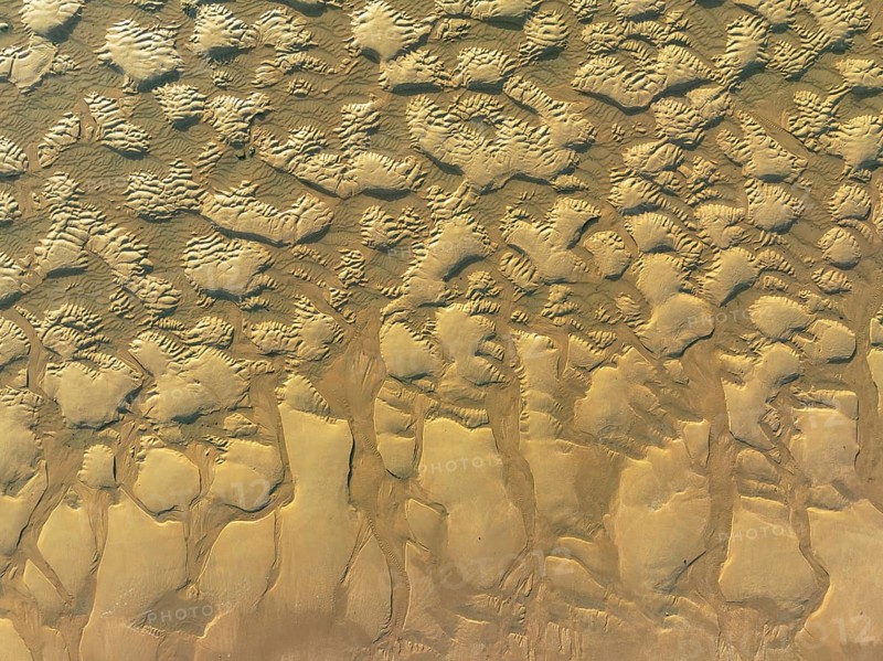 Sandy shapes at low tide at the shore of the Atlantic Ocean near Cape Trafalgar. Aerial view. Drone shot. Costa de la Luz, Cadiz province, Andalusia, Spain, Europe
