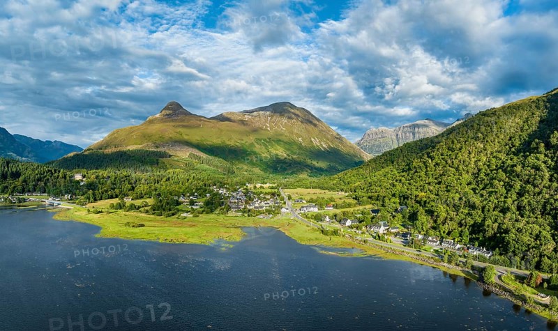 Aerial panorama of the freshwater loch Loch Leven with the village of Glen Coe, above it the 742 metre high Pap of Glencoe, Highlands, Scotland, United Kingdom, Europe