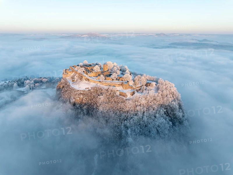 Aerial view of the Hegau volcano Hohentwiel with Germany's largest fortress ruins on a cold, foggy winter morning, at sunrise, on the horizon seen from the left the Hegau mountains Hohenstoffeln, Hohenhewen and MÃ¤gdeberg, Singen am Hohentwiel, district of Constance, Baden-Württemberg, Germany, Europe