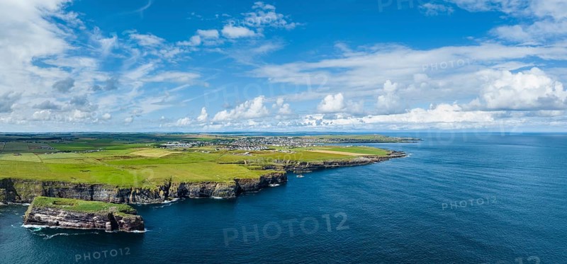Aerial panorama of rugged cliffs on the North Sea coast, with the harbour town of Wick on the horizon, County Caithness, Scotland, United Kingdom, Europe