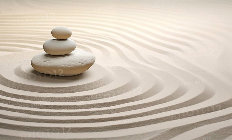 Zen stones stack on raked sand waves in a minimalist setting for balance and harmony. Balance, harmony, and peace of mind, wellness, meditation, and spirituality concept, AI generated