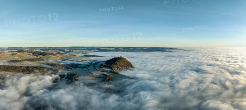 Aerial panorama of the wintry and fog-covered Hegaulandschaft shortly after sunrise, the volcanic cone Hohenhewen rises out of the sea of fog, district of Constance, Baden-Württemberg, Germany, Europe