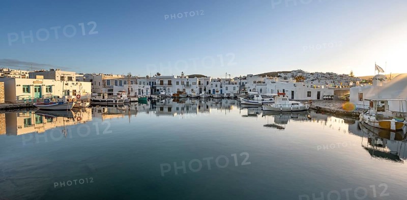 Fishing boats in the harbour of Naoussa at sunset, reflected in the sea, White Cycladic houses, Naoussa, Paros, Cyclades, Greece, Europe