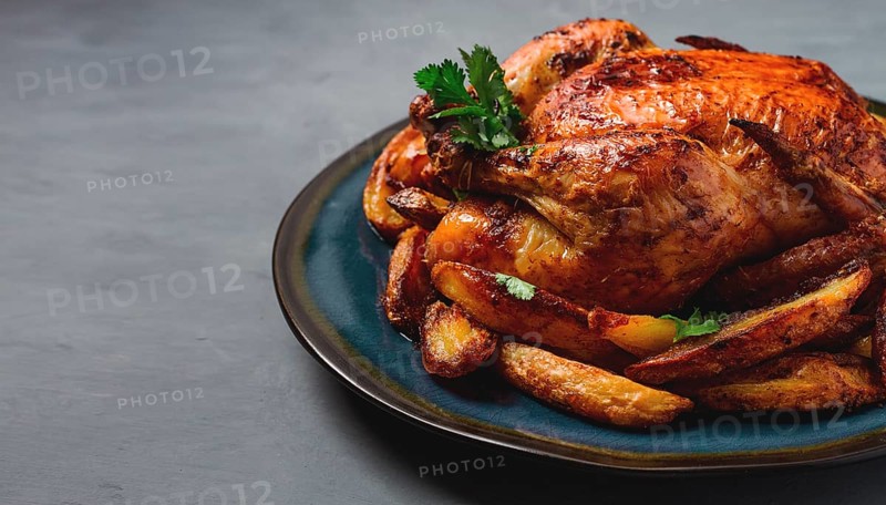Fried whole chicken, with potatoes, on a gray background, no people