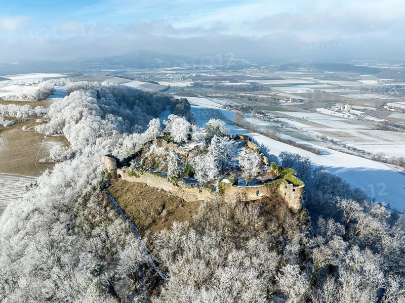 Aerial view of the snow-covered Hegau volcano MÃ¤gdeberg, with remains of a castle wall, surrounded by frosty trees in a winter landscape, district of Constance, Baden-Württemberg, Germany, Europe