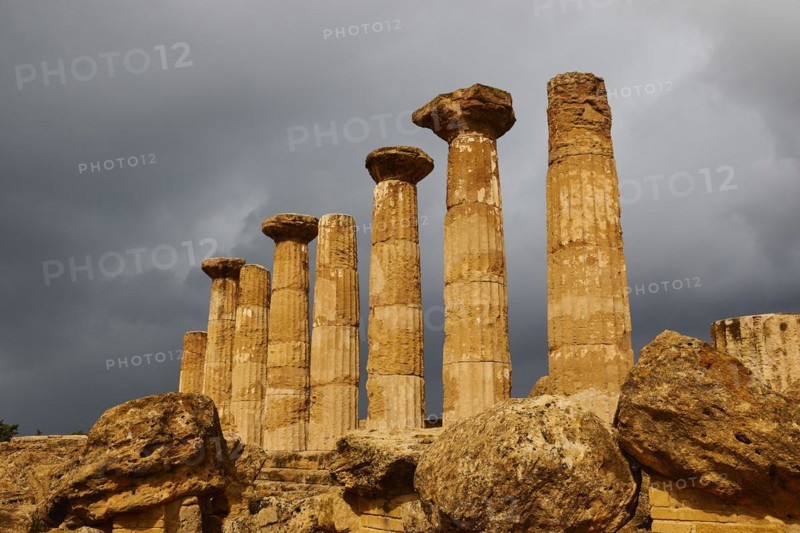 Row of columns, chapter, Heracles temple, dark clouds, sun, thunderstorm atmosphere. Valley of the temples, valle dei templi, Agrigento, Sicily, Italy, Europe
