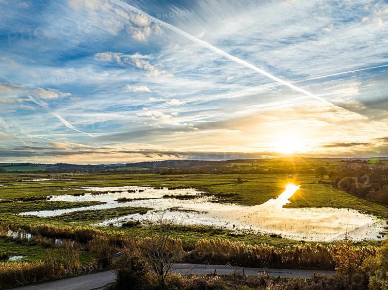 Sunset over Wetlands and Marshes in RSPB Exminster and Powderham Marshe from a drone, Exeter, Devon, England, United Kingdom, Europe