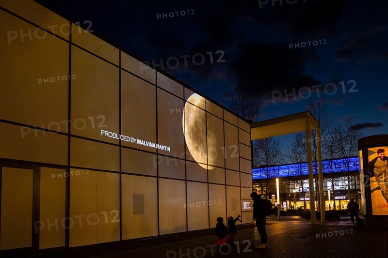 Art event Erlebnis (welt) raum on Prager StraÃŸe with VR artist Max Salomon. On the occasion of the 50th anniversary of the Apollo mission, a 3 d spectacle was created from the photographic documentation of the astronauts, which is projected onto a house wall