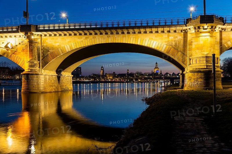 Albertbrücke and Church of Our Lady with the glass dome over the octagon of the Academy of Arts, which is illuminated in blue in protest against the Ukraine war