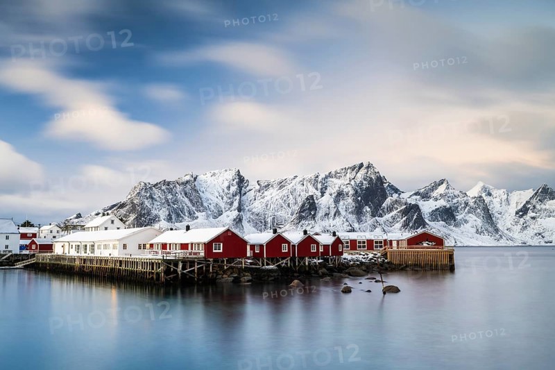 Rorbuer cabins of Hamnoy by the fjord, snowy mountains in the back, Hamnoy, Reine, Moskenesoya, Lofoten, Norway, Europe