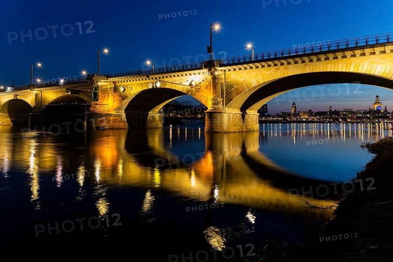 Albertbrücke and Church of Our Lady with the glass dome over the octagon of the Academy of Arts, which is illuminated in blue in protest against the Ukraine war