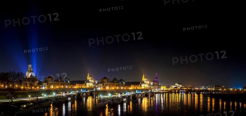Dresden Silhouette View of the Old Town from the Carola Bridge. On the occasion of the commemoration of the 70th anniversary of the destruction of Dresden, floodlights shine into the night sky at the Church of Our Lady