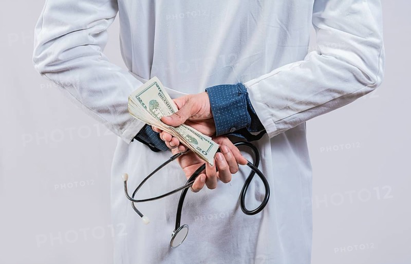Medical corruption and bribery concept. Corrupt doctor hiding money back, Dishonest doctor hiding money