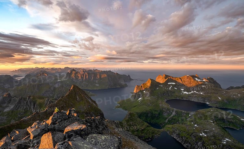 View over mountain peaks and sea, dramatic sunset, mountaineers at Hermannsdalstinden, with lakes Litlforsvatnet and Tennesvatnet and fjord Forsfjorden, Moskenesöy, Lofoten, Nordland, Norway, Europe