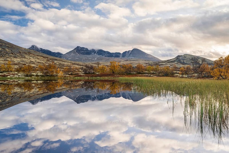 Reflection of the autumn landscape in Rondane National Park, mountains Hogronden, Midtronden and Digerronden Doralen, Doralseter, Norway, Europe