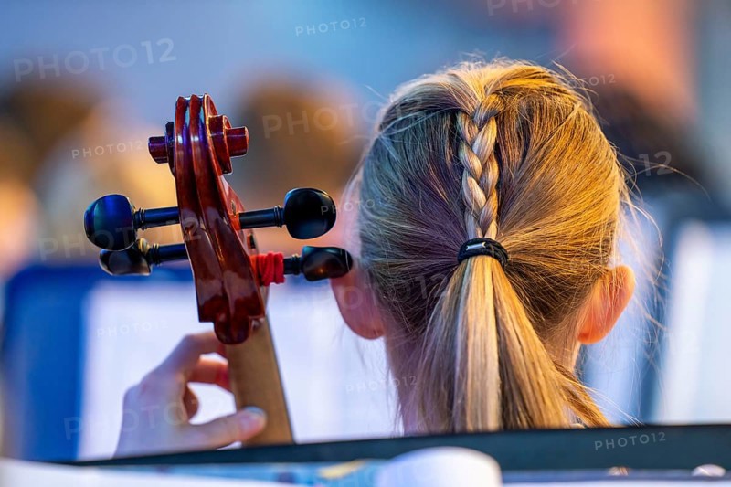 Young girl plays a cello at a concert
