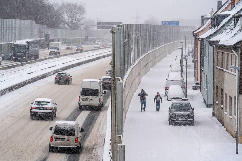 A40 motorway, onset of winter, lots of fresh snow and daytime temperatures below minus 5 degrees, uncleared carriageway, little traffic, poor road conditions, noise barrier, quiet residential road, at the Essen-Ost motorway junction, Essen, North Rhine-Westphalia, Germany, Europe