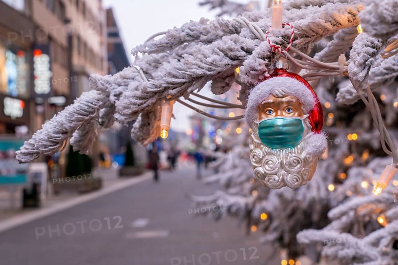 Symbolic picture Christmas in the Corona crisis, Father Christmas figure, Christmas tree decoration, with mouth-nose mask, everyday mask, in a pedestrian zone, shopping street